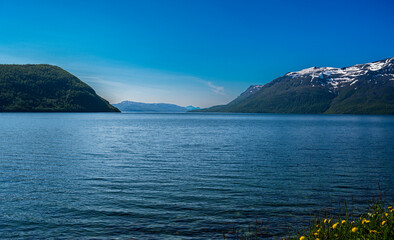 Rocky hills covered with snow above sea bay