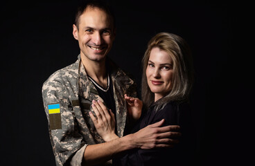 Happy Ukrainian couple who met after the war. A military man in uniform hugs his happy wife