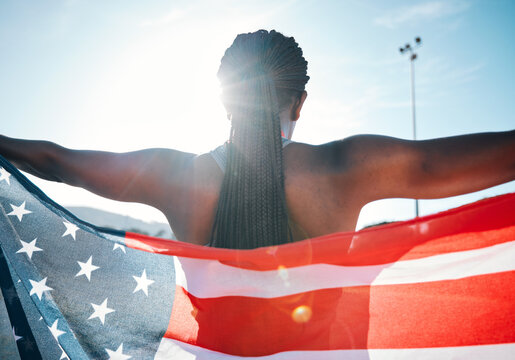 Athlete, American flag and sports with a woman outdoor at a stadium to celebrate country, pride and win. Back of a person for olympic sport, fitness and exercise achievement at competition in USA - Powered by Adobe