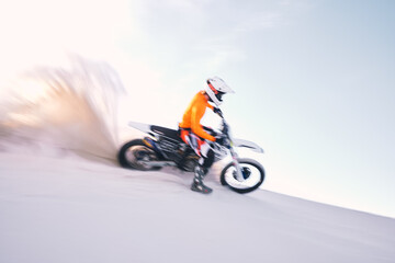 Bike, dust and motion blur with a sports man riding a vehicle in the desert for adventure or adrenaline. Motorcycle, training and speed with an athlete on sand in nature for speed, freedom or energy