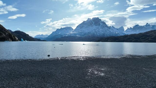 Grey Lake At Torres Del Paine In Ultima Esperanza Chile. Snowy Mountains. Lake Landscape. Ultima Esperanza Chile. Winter Background. Grey Lake At Torres Del Paine In Ultima Esperanza Chile.