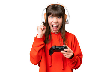 Little caucasian girl playing with a video game controller over isolated background celebrating a...
