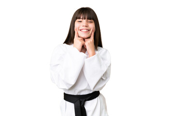 Little Caucasian girl doing karate over isolated background smiling with a happy and pleasant expression © luismolinero