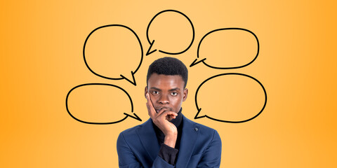Pensive young African businessman and speech bubbles
