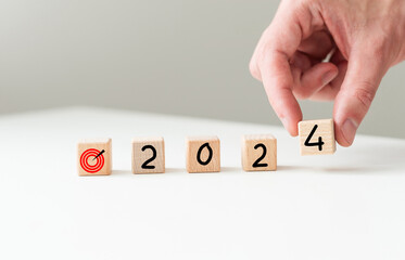 2024 new year goal planning idea, wood block cube on wooden table with new year 2024 and target icon, business vision.