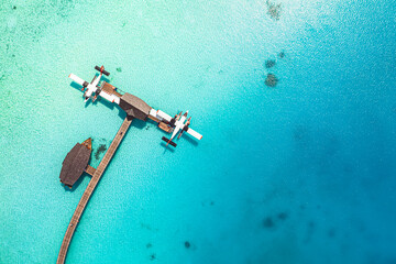 Beautiful aerial view of Maldives coast, pier water villa seaplane top view, wooden boat and...