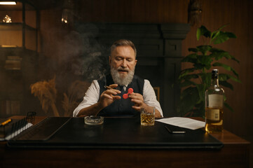 Old-fashioned elegant senior businessman playing spinner toy