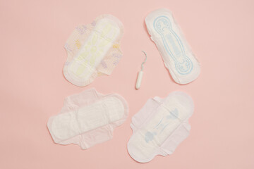 Different feminine sanitary napkins (sanitary pads) with tampon on pink background