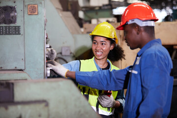 worker or engineer training and teaching how to use machine control with coworker in factory