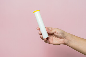 Hand holding bottle for pills, effervescent tablets or vitamin
