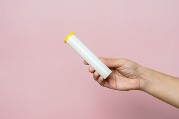 Hand holding bottle for pills, effervescent tablets or vitamin