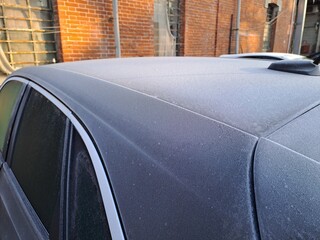 Icy car from winter temperatures. Frost coats car, side view.