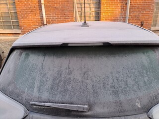 Icy car from winter temperatures. Frost covers the car, rear window view.