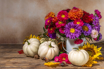 Flowers and pumpkins on table