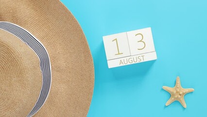 August. Wooden calendar on a blue background with summer accessories, top view. Holidays in summer. Perpetual calendar, hat and starfish. Alternate change of dates from 1 to 31