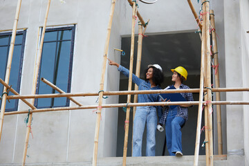 workers or architect looking and pointing at construction site