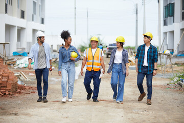 workers or architect walking and talking about work on the construction site