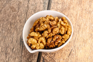 Cracked unshelled walnut in the bowl