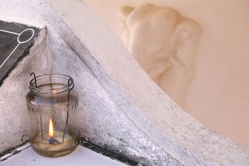 Candle burning in a jar near the temple