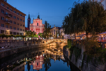 Ljubljana, Slovenia - Illuminated Tromostovje bridge and Franciscan Church of the Annunciation with...