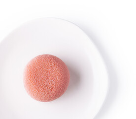Pink mousse cake on white plate