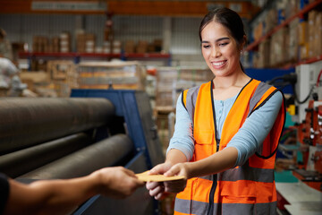 worker taking a cash in the envelope from employer in the warehouse storage