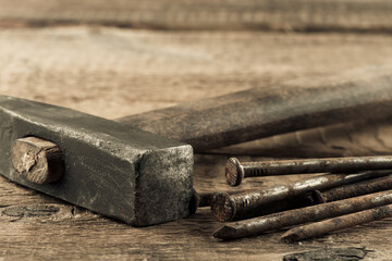 Vintage hammer with nails on wood background