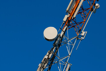 Communications tower with antennas on blue sky