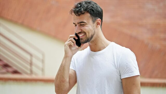 Young hispanic man smiling confident talking on the smartphone at street