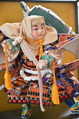 五月人形の重いお寺の釣鐘を背負った男の子