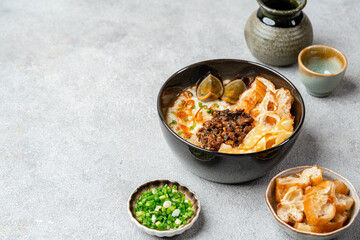 Rice porridge or congee with minced pork, century egg and cakwe in bowl