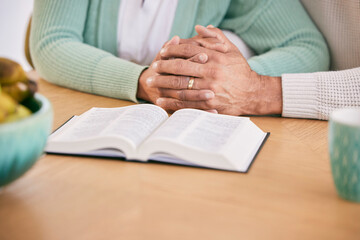 Reading, bible and senior couple holding hands at home with book study and religion together....