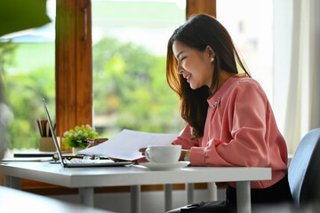 Happy asian businesswoman using laptop working on new startup project at her office