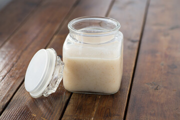 shio koji sauce in a glass bottle on top of wooden table with wooden spoon