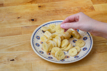 Banan beż skórki, pokrojony w plasterki na talerzu
