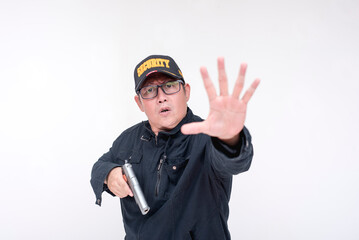 A male security guard commands someone to stop, gesturing with his hand while taking out his gun. Alert and ready to defend himself. Isolated at a white background.