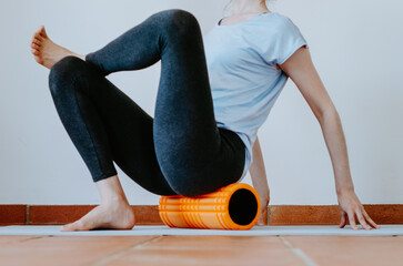 Woman doing glute myofascial release on foam roller