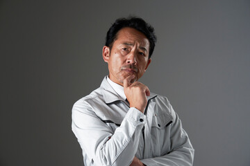 考えるミドルエイジの作業員　黒背景