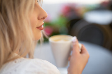 close-up of the face of a beautiful girl drinking coffee