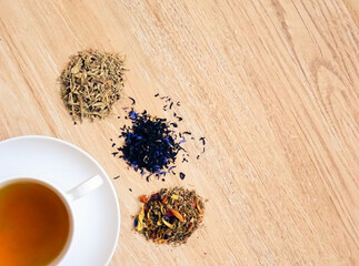 Tea cup with varieties of dry tea. herbs, black, green, fruit tea, chamomile, valerian, linden,...