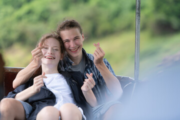 A young couple sits on a boat for a journey into the forest above the dam for trekking.