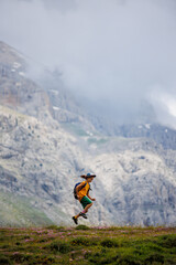 boy with a backpack on a hike against the backdrop of the mountains. child traveler with backpack, hiking, travel, mountains in the background, kids summer vacation.