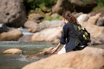 Young woman with backpack hiking in the forest. Active lifestyle concept.