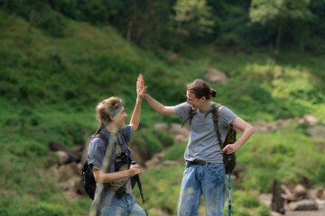 Two man hiking in the forest with backpacks and trekking poles