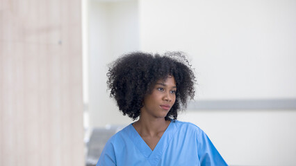 Female African nurse or emergency physician with smiling face stands ready for her service. - obrazy, fototapety, plakaty