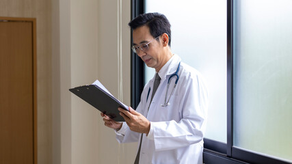 Male medical doctor or beauty surgeon stands with smile greeting to patient in front of his clinic.