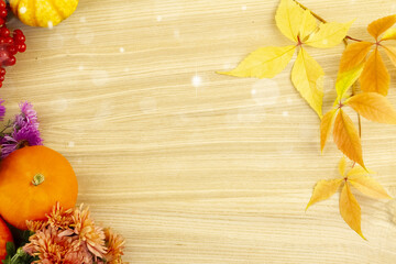 Autumn card with pumpkins, berries, flower leaves on a wooden background. Autumn background with...
