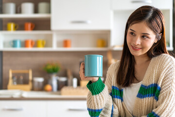 Portrait of smiling happy cheerful beauty pretty asian woman relaxing drinking and looking at cup of hot coffee or tea.Girl felling enjoy having breakfast in holiday morning vacation at home