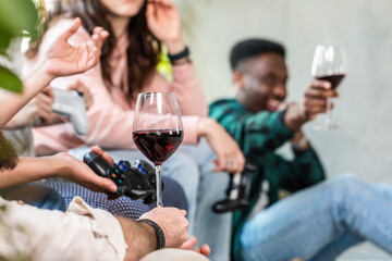Selective focus on a boy's hand holding a goblet of red wine