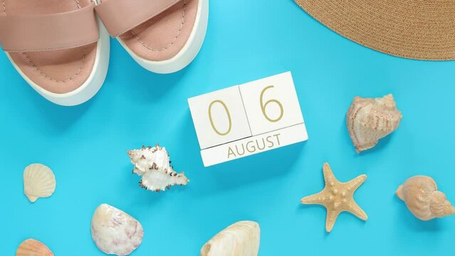August. Wooden calendar on a blue background with summer accessories, top view. Vacation in summer. Perpetual calendar, boots, hat and shells with starfish. Alternate change of dates from 1 to 31